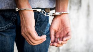 Particolare delle manette di un uomo in arresto.