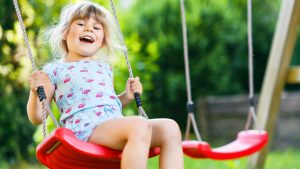 Bimba si diverte su un'altalena