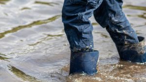Uomo si fa strada nell'alluvione