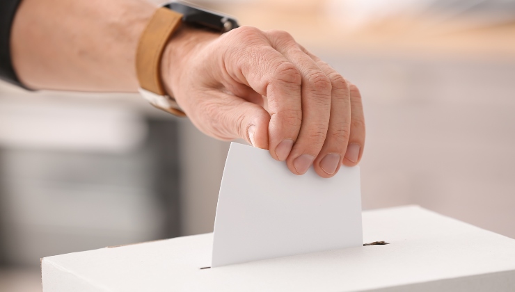 Uomo mette una scheda elettorale nell'urna
